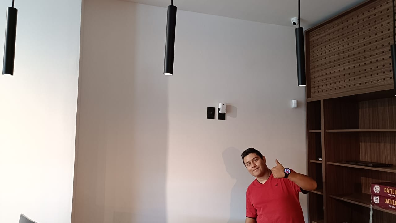 Interior de un local con cámara en la parte superior y una persona junto al mostrador