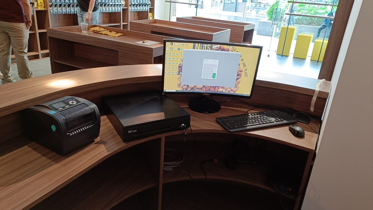 Monitor, teclado, impresora y cajón de dinero en un mostrador
