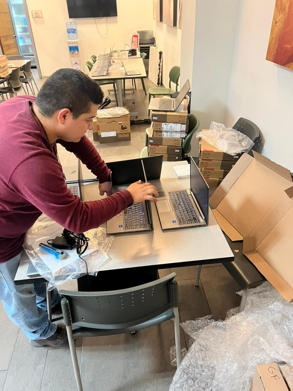 Persona trabajando con varias laptops sobre mesas